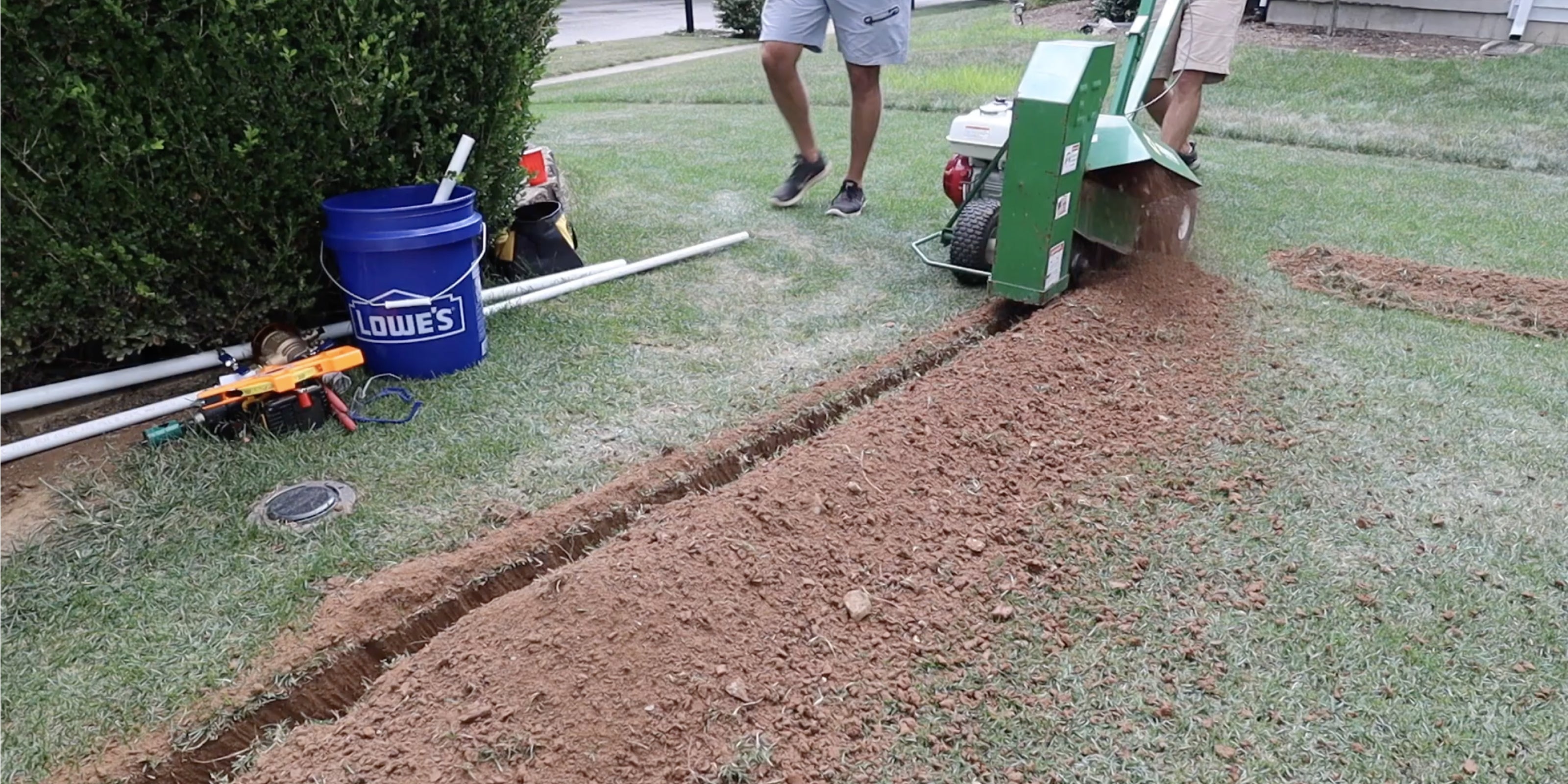 Trenching machine cutting slim irrigation trench in lawn for minimal yard disruption